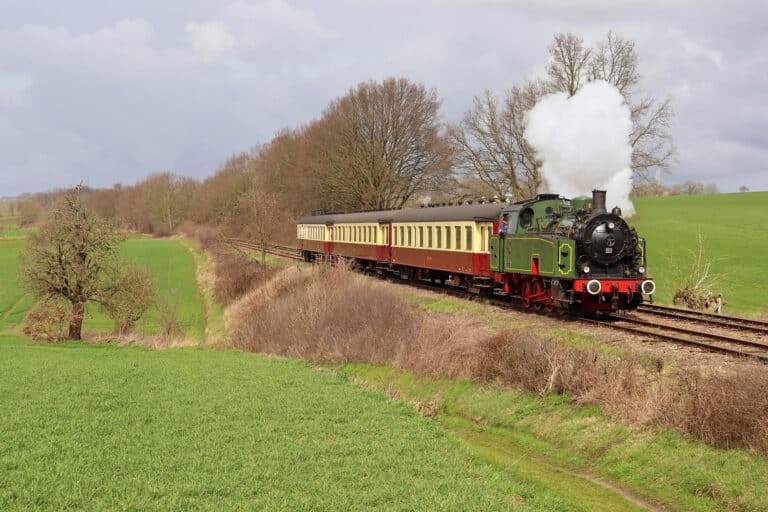 Photo of a steam locomotive pulling vessels.