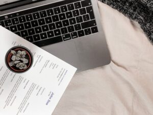 Photo of a laptop with a printed resume on it.