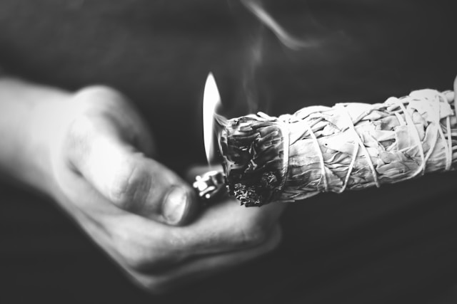 Photo of hands that are burning white sage
