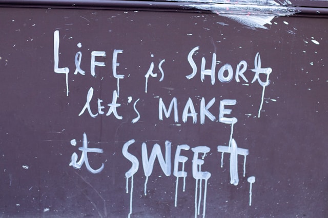 Photo of a sign with the words "Life is short, let's make it sweet" written on it